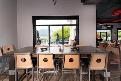 a dining room with a large wooden table and chairs at Prestige Harbourfront Resort, WorldHotels Luxury in Salmon Arm
