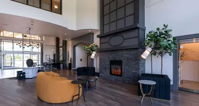 a living room with a fireplace and a couch and chairs at Prestige Harbourfront Resort, WorldHotels Luxury in Salmon Arm