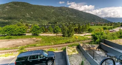 a black suv parked in a parking lot in front of a mountain at Prestige Inn Nelson in Nelson