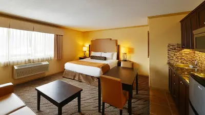 a hotel room with a bed and a desk in it at Prestige Golden Hotel in Golden