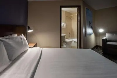 a bedroom with a large white bed and a bathroom at Prestige Mountain Resort Rossland in Rossland