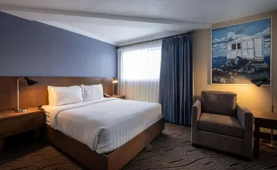 a hotel room with a bed and a chair at Prestige Mountain Resort Rossland in Rossland