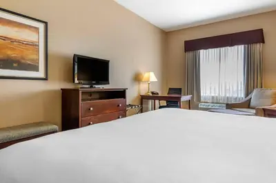 a hotel room with a bed and a flat screen tv at Quality Inn & Suites in Rimbey