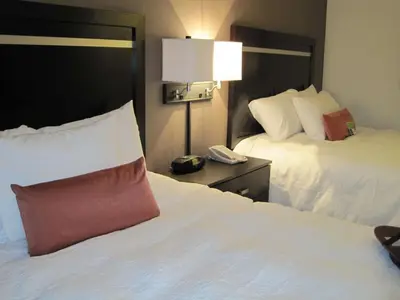 a hotel room with two beds and a phone on a table at Hampton Inn by Hilton Fort Saskatchewan in Fort Saskatchewan