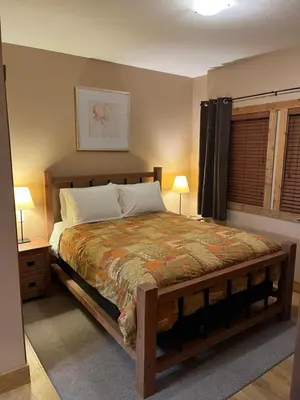 a bedroom with a bed and two lamps and a window at Casa Del Mila Oro in Osoyoos