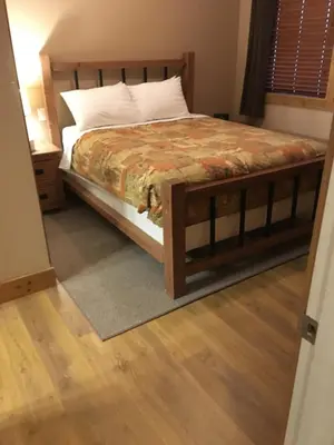 a bedroom with a bed and a wooden floor at Casa Del Mila Oro in Osoyoos