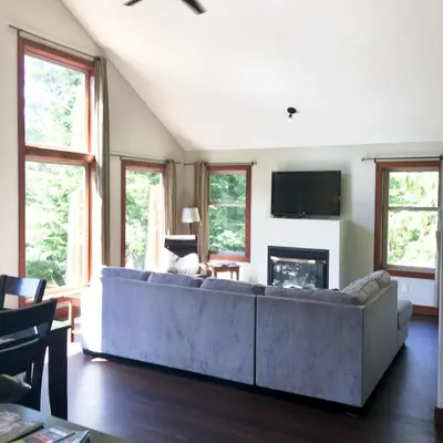 a living room with a couch and a fireplace at Cobble Wood and Bird Sanctuary Guest Houses in Tofino