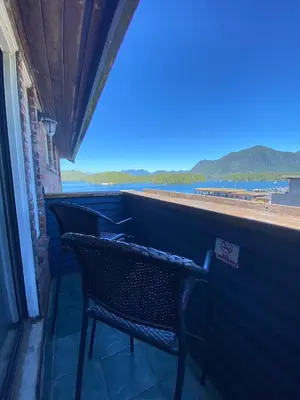 a balcony with two chairs and a view of the water at The Inn at Tough City in Tofino
