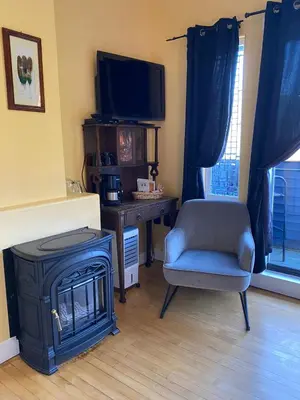 a living room with a chair and a stove at The Inn at Tough City in Tofino