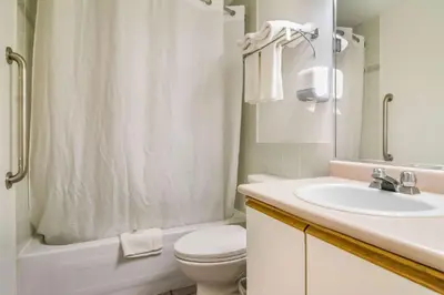 a white bathroom with a toilet and a sink at Motel 6 Surrey, Bc in Surrey