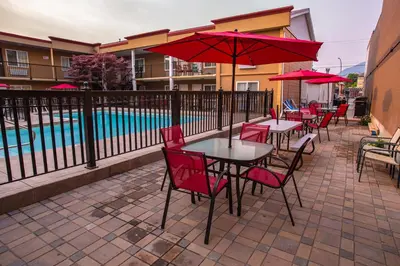 a patio with tables and chairs and a pool at Sahara Courtyard Inn Penticton in Penticton