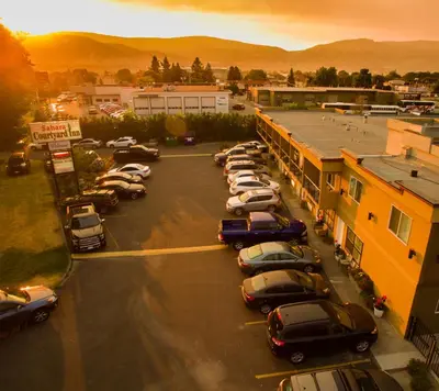 a parking lot with cars parked in front of a building at Sahara Courtyard Inn Penticton in Penticton