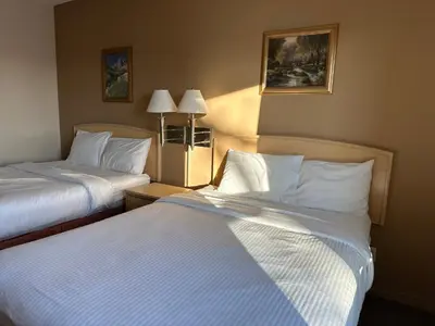 a hotel room with two beds and two lamps at Lone Star Hotel in North Battleford