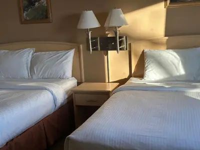a hotel room with two beds and two lamps at Lone Star Hotel in North Battleford