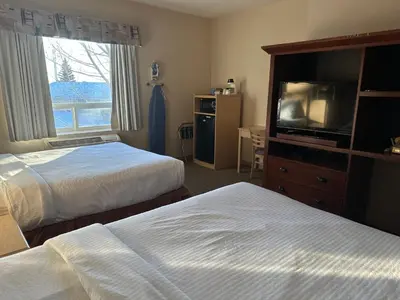 a hotel room with two beds and a flat screen tv at Lone Star Hotel in North Battleford
