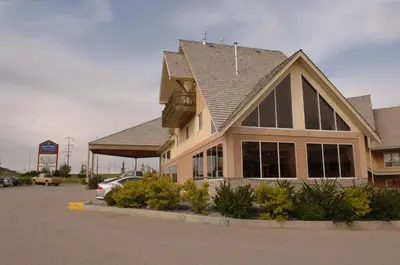 a building with a car parked in a parking lot at Lakeview Inns & Suites - Hinton in Hinton