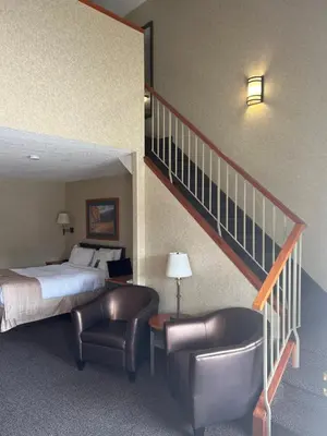 a hotel room with a bed and a staircase at Lakeview Inns & Suites - Hinton in Hinton