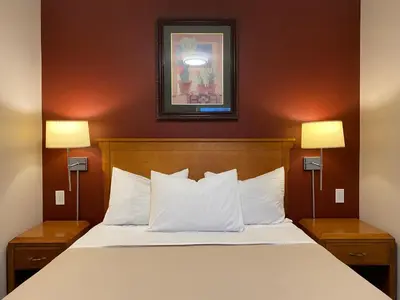 a bed in a hotel room with two lamps at Sahara Courtyard Inn & Suites Osoyoos in Osoyoos