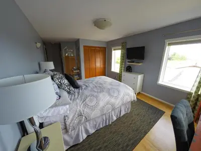 a bedroom with a bed and a window at Money Pennies Bed and Breakfast in Campbell River