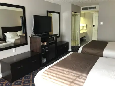 a hotel room with two beds and a flat screen tv at Chateau Louis Hotel & Conference Centre in Edmonton