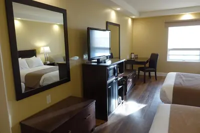 a hotel room with a bed and a mirror at Chateau Louis Hotel & Conference Centre in Edmonton