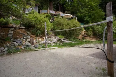 a gate in a garden with a house in the background at Halfmoon Haven Beach Cottage or Oceanview Suite in Halfmoon Bay