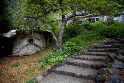 a set of stone steps leading to a tree at Halfmoon Haven Beach Cottage or Oceanview Suite in Halfmoon Bay
