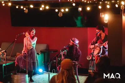a group of people singing on a stage at The Maq Hotel in Tofino