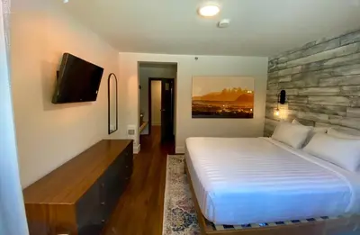 a bedroom with a bed and a flat screen tv at The Maq Hotel in Tofino