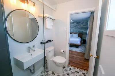 a bathroom with a sink and a toilet and a mirror at The Maq Hotel in Tofino