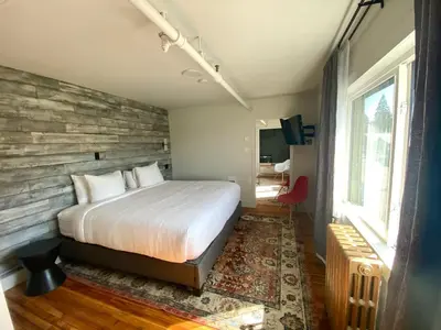 a bedroom with a bed and a brick wall at The Maq Hotel in Tofino