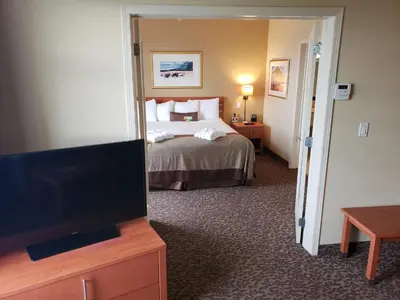 a hotel room with a bed and a flat screen tv at Wingate by Wyndham - Edmonton West in Edmonton