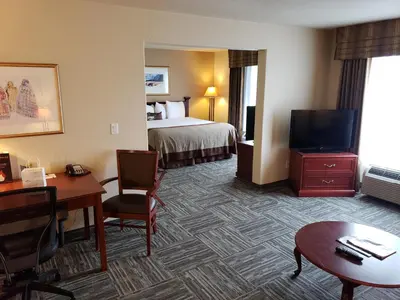 a hotel room with a bed and a flat screen tv at Wingate by Wyndham - Edmonton West in Edmonton