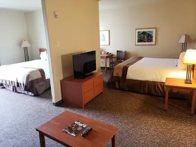 a hotel room with two beds and a flat screen tv at Wingate by Wyndham - Edmonton West in Edmonton