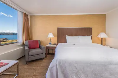 a hotel room with a bed and a chair and a window at Coast Discovery Inn in Campbell River