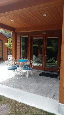 a patio with a table and chairs in front of a house at Nestledown B&B in Halfmoon Bay
