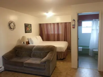 a living room with a couch and a bed in a room at Edgewater Motel in Oyster Bay