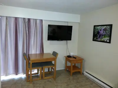a hotel room with a table and a television on the wall at Edgewater Motel in Oyster Bay