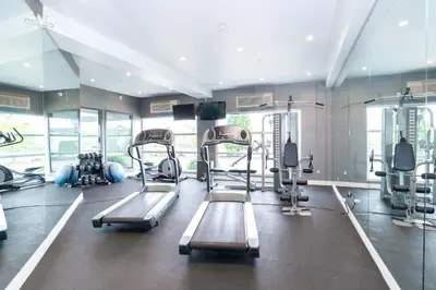 a gym with several tread machines in a room at Sandman Signature Langley Hotel in Langley