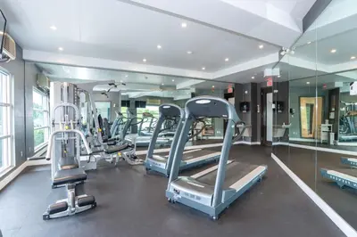 a gym with several treadmills and a mirror at Sandman Signature Langley Hotel in Langley
