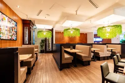 a restaurant with tables and chairs and chandeliers at Sandman Signature Langley Hotel in Langley