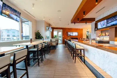a bar with tables and chairs in a restaurant at Sandman Signature Langley Hotel in Langley