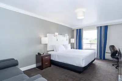 a hotel room with a bed and a couch at Sandman Signature Langley Hotel in Langley