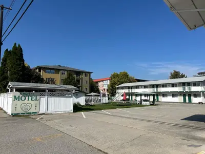 a motel parking lot with a building in the background at Empire Motel in Penticton