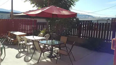 a patio with tables and chairs and an umbrella at Cactus Tree Inn in Oliver