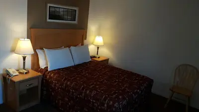 a hotel room with a bed and two lamps at Cactus Tree Inn in Oliver