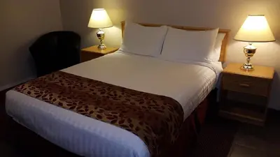 a hotel room with a large bed with two lamps at Cactus Tree Inn in Oliver