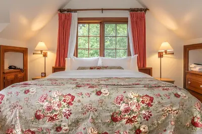 a bedroom with a large bed with a large window at Hastings House Country House Hotel in Ganges