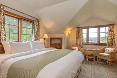 a bedroom with a large white bed and windows at Hastings House Country House Hotel in Ganges