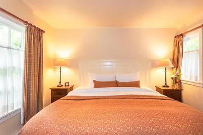 a bedroom with a large bed and two windows at Hastings House Country House Hotel in Ganges